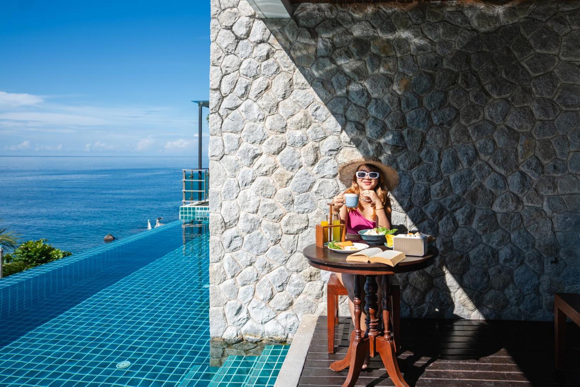 Zenmaya Oceanfront Phuket, Trademark Collection By Wyndham Patong Exterior foto A woman enjoying a morning coffee at the poolside of the resort